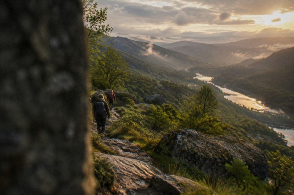 Hikers on a granite trail above a river valley in Peneda-Gerês National Park