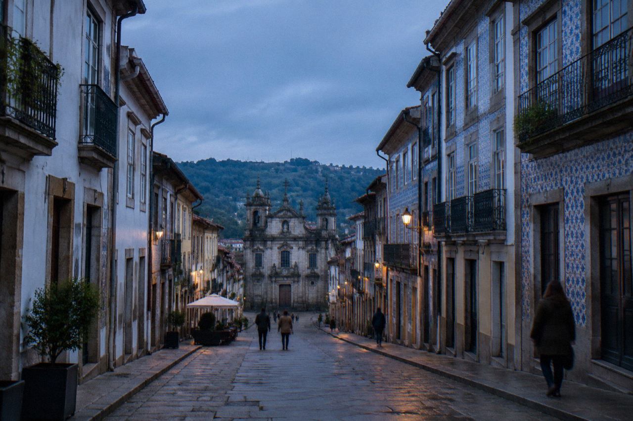 Visitors reading a map outside a café on a pedestrian street in Braga's historic centre