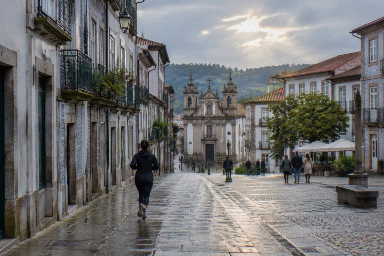 Cobbled square in the historic centre of Guimarães with old buildings and people walking