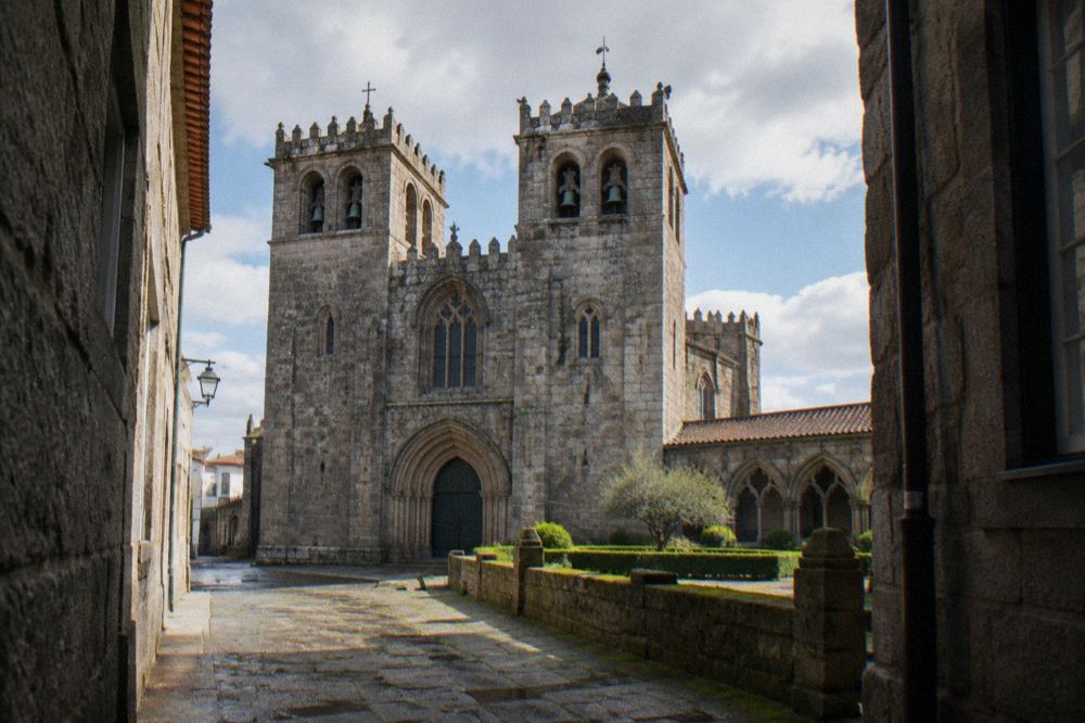 The twin-towered facade of Braga cathedral seen from a narrow street in the historic centre