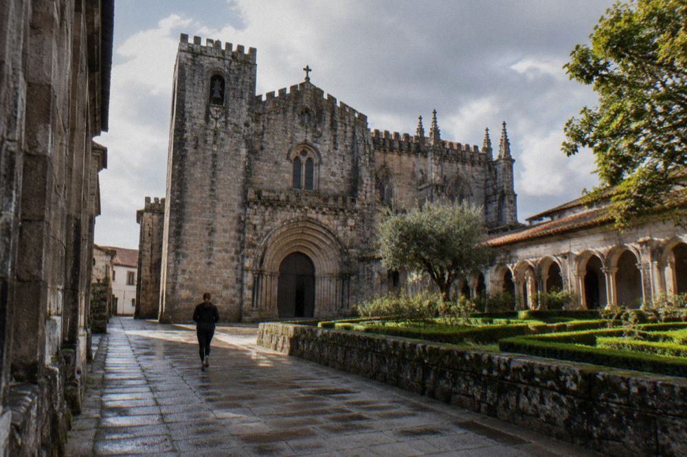 Sunlight falling on carved stone arches and a tiled wall inside an old Portuguese church