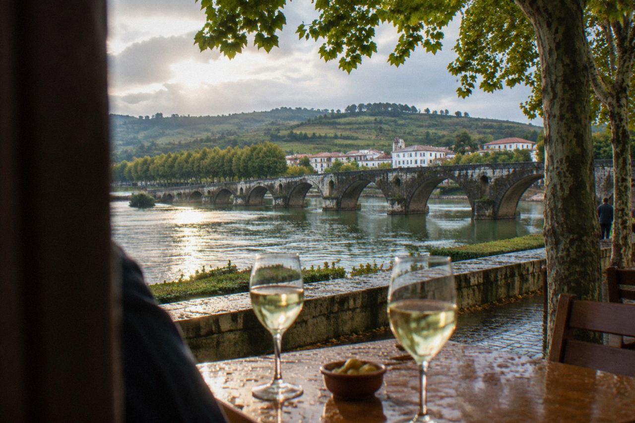 Glasses of pale Vinho Verde wine on a wooden table in a Minho wine region setting