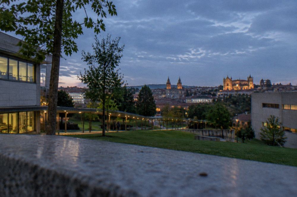 Evening view of Braga's historic rooftops with church towers lit at dusk