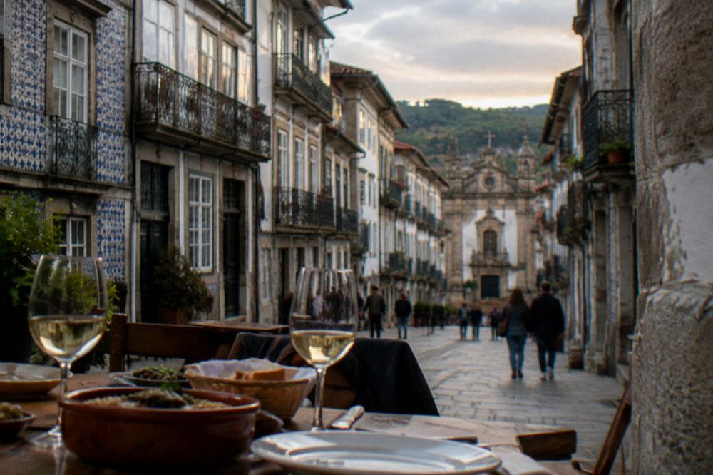 A dinner table with wine glasses and regional dishes at a restaurant in Braga