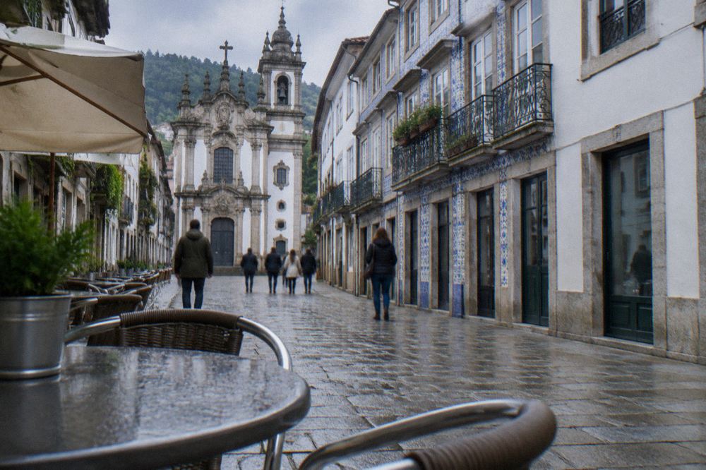 Café tables and pedestrians on a stone-paved street in Braga's old town