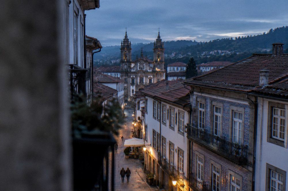 The rooftops and church towers of Braga seen from a high viewpoint at dusk