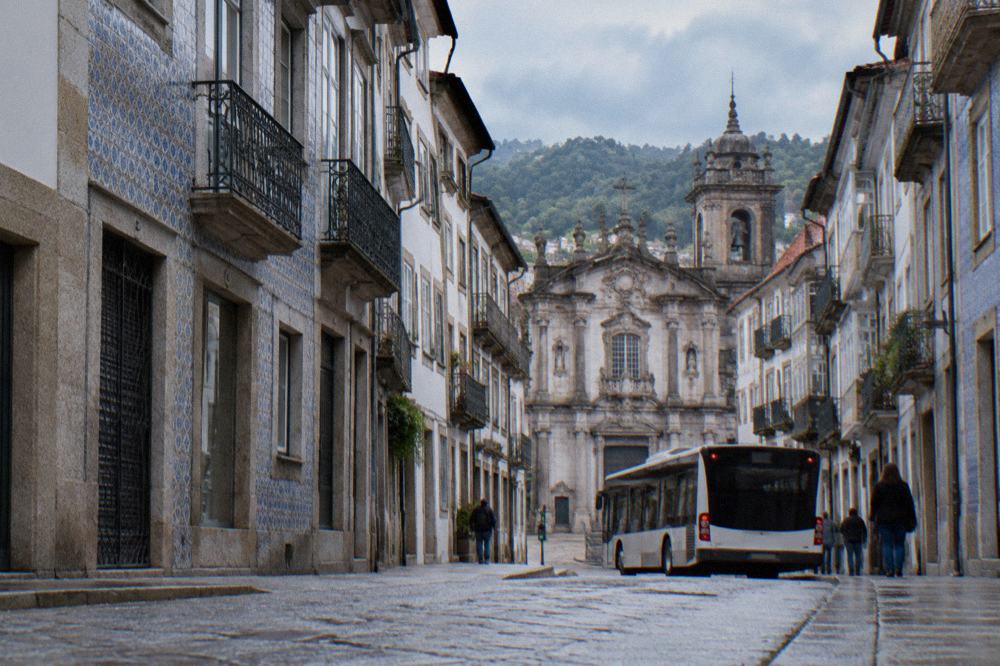 A city bus stopped at a street corner in a residential Braga neighbourhood