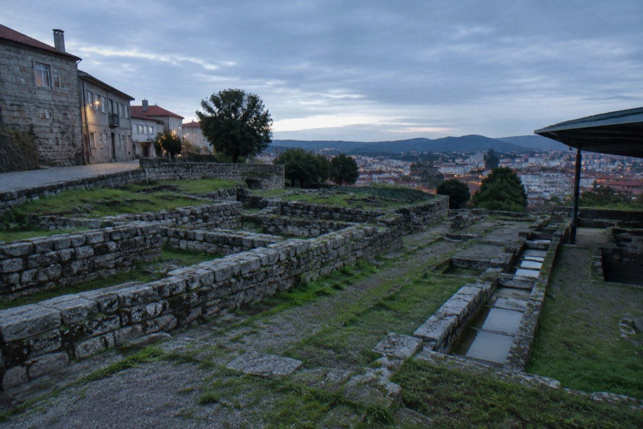 A quiet residential street on the Cividade hillside in Braga with stone buildings and the city spreading below