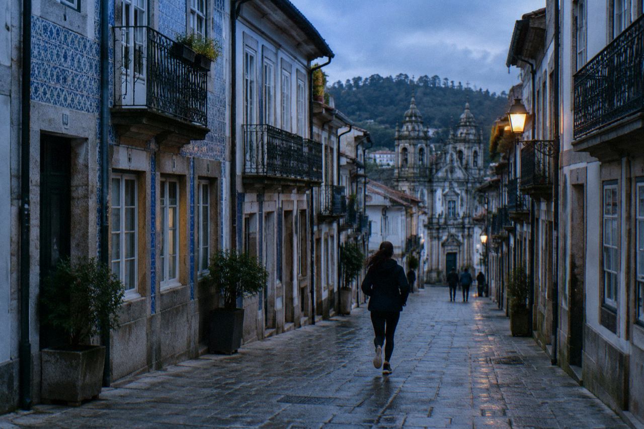 A quiet residential street in Braga with traditional Portuguese buildings and church towers in the distance