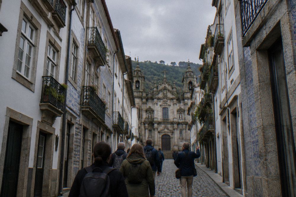 A guide leading a small group of visitors along a cobbled street in Braga