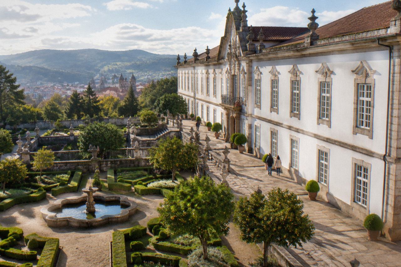 The stone facade and garden of a Baroque palace museum in Braga on a sunny afternoon