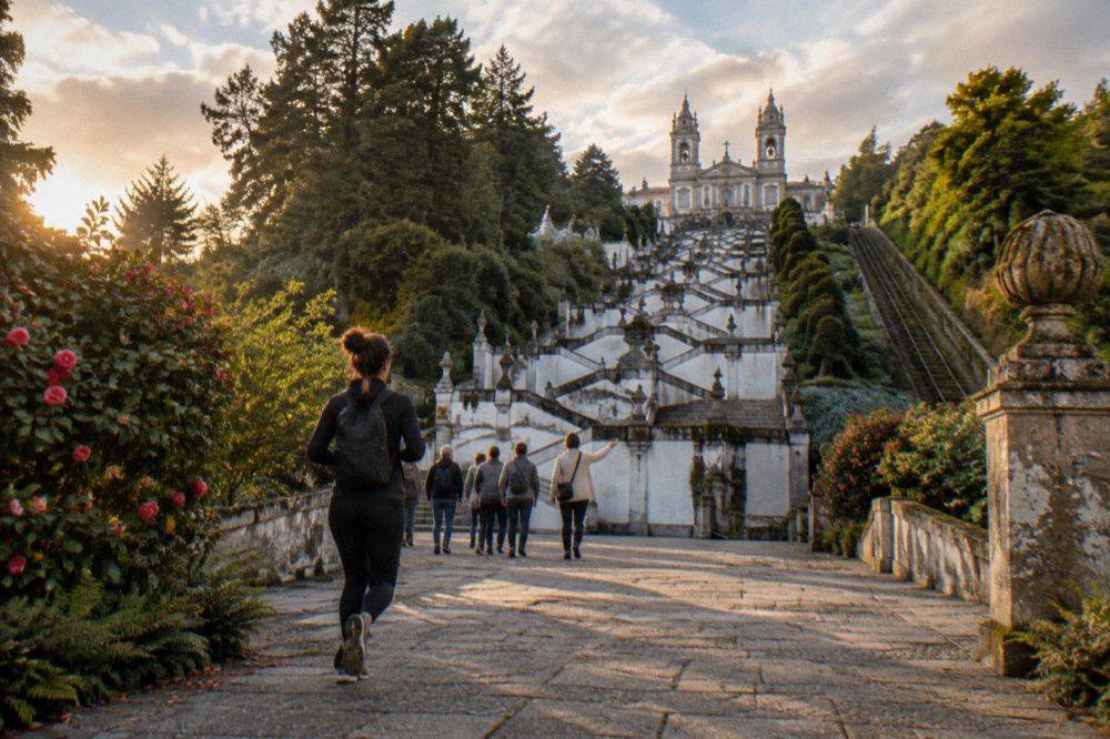 A guide leading a small group of visitors across the terrace in front of the Bom Jesus basilica