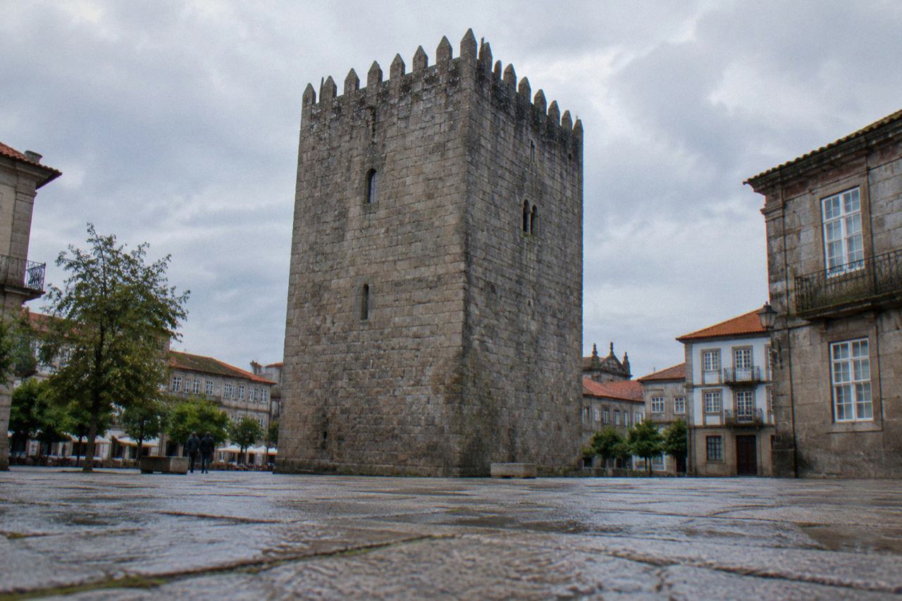 A stone medieval keep tower rising above rooftops in a Portuguese city