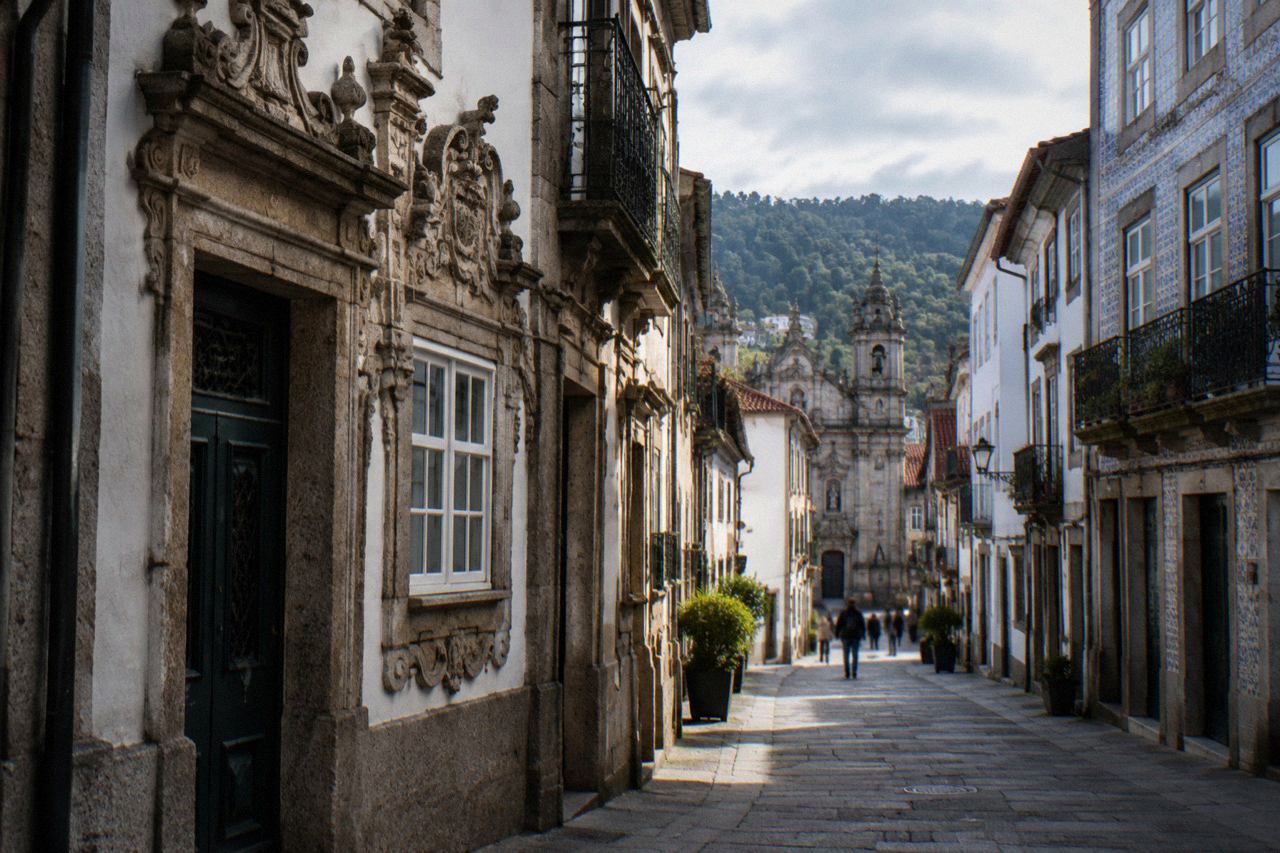 A historic granite house with an ornate decorated facade on a narrow street in Braga