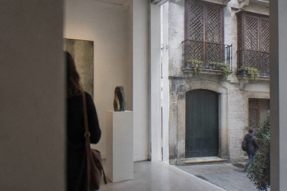 A bright gallery room with white walls inside a restored old Portuguese building
