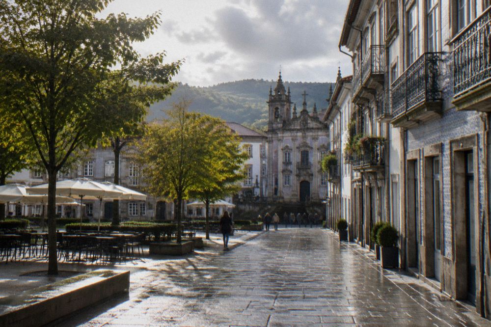 A sunny morning in a Braga square with trees and historic building facades