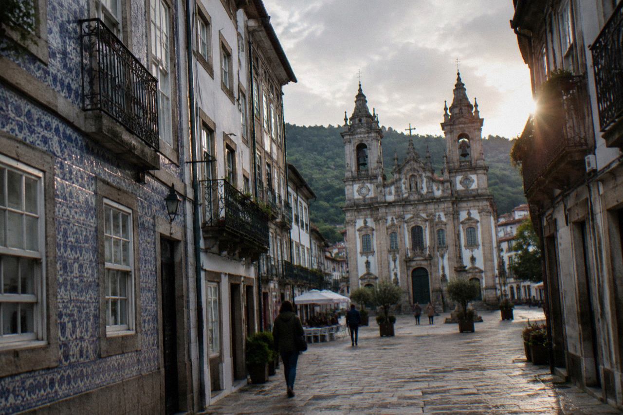 Twin-towered baroque church façade in Braga with ornate stonework seen from a city square