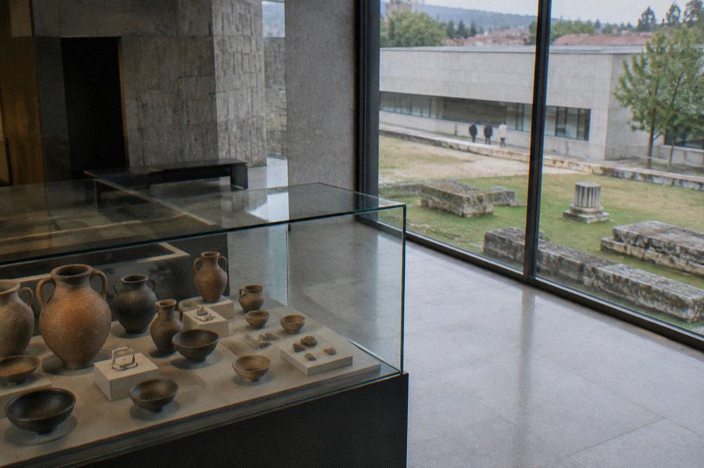 Glass display case with Roman pottery vessels and small finds