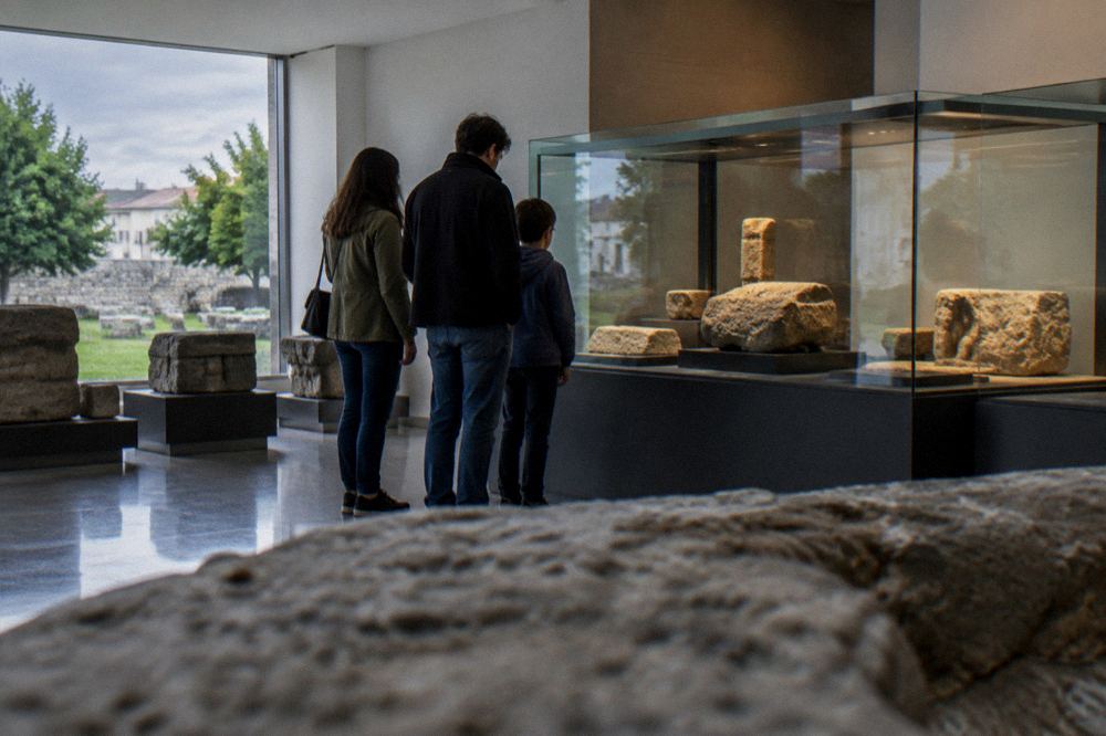 Family looking at a display of ancient stone objects in a museum room