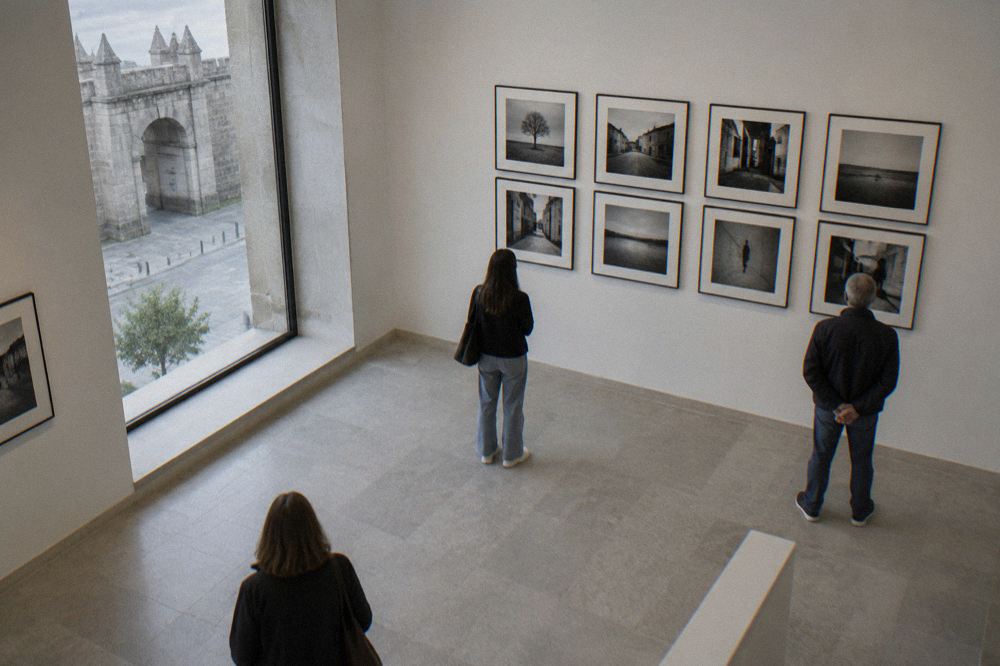 A restored interior gallery with white walls and framed photographs hung in a grid