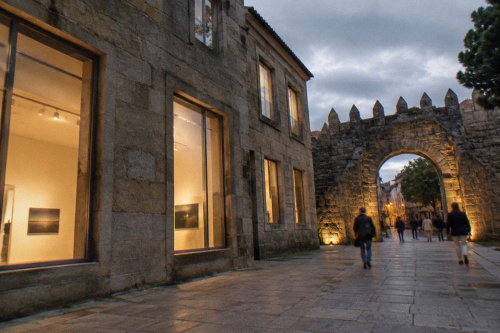 A stone archway in Braga's old city walls with evening light and people passing through