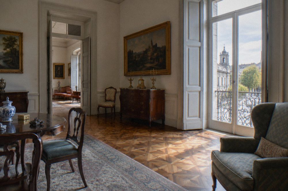 A period drawing room with antique furniture, framed paintings and patterned floors