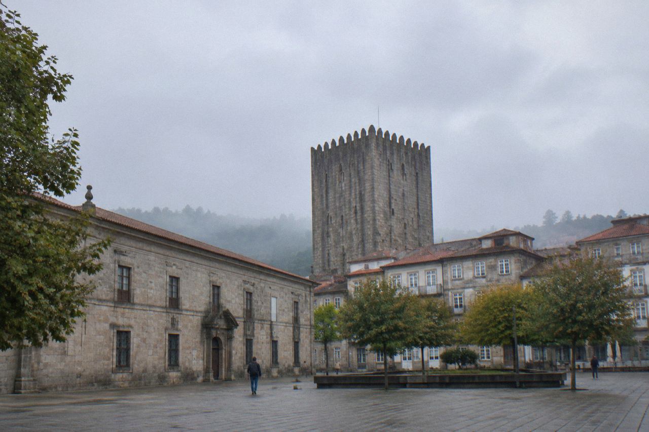 The stone facade of the Museu Pio XII in Braga with the Medieval Tower rising behind the rooftops