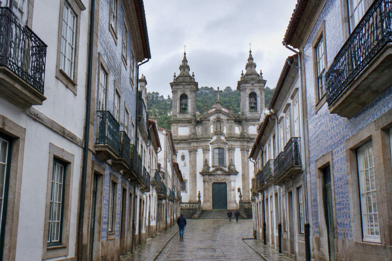 Baroque church facade with twin bell towers on a quiet street in Braga
