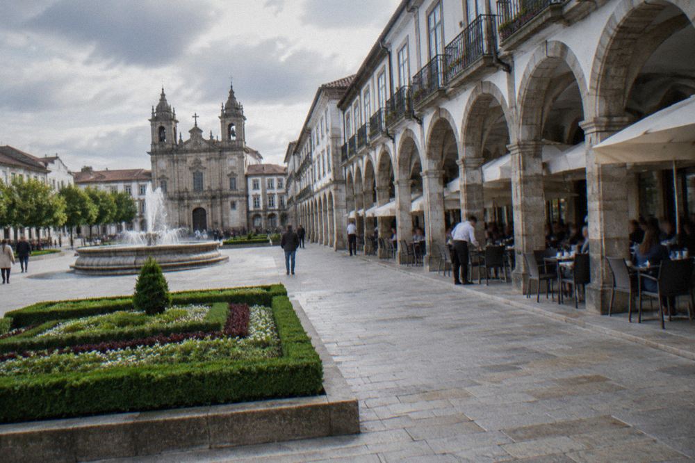 Café terraces under the Arcada arches with waiters serving tables in the afternoon