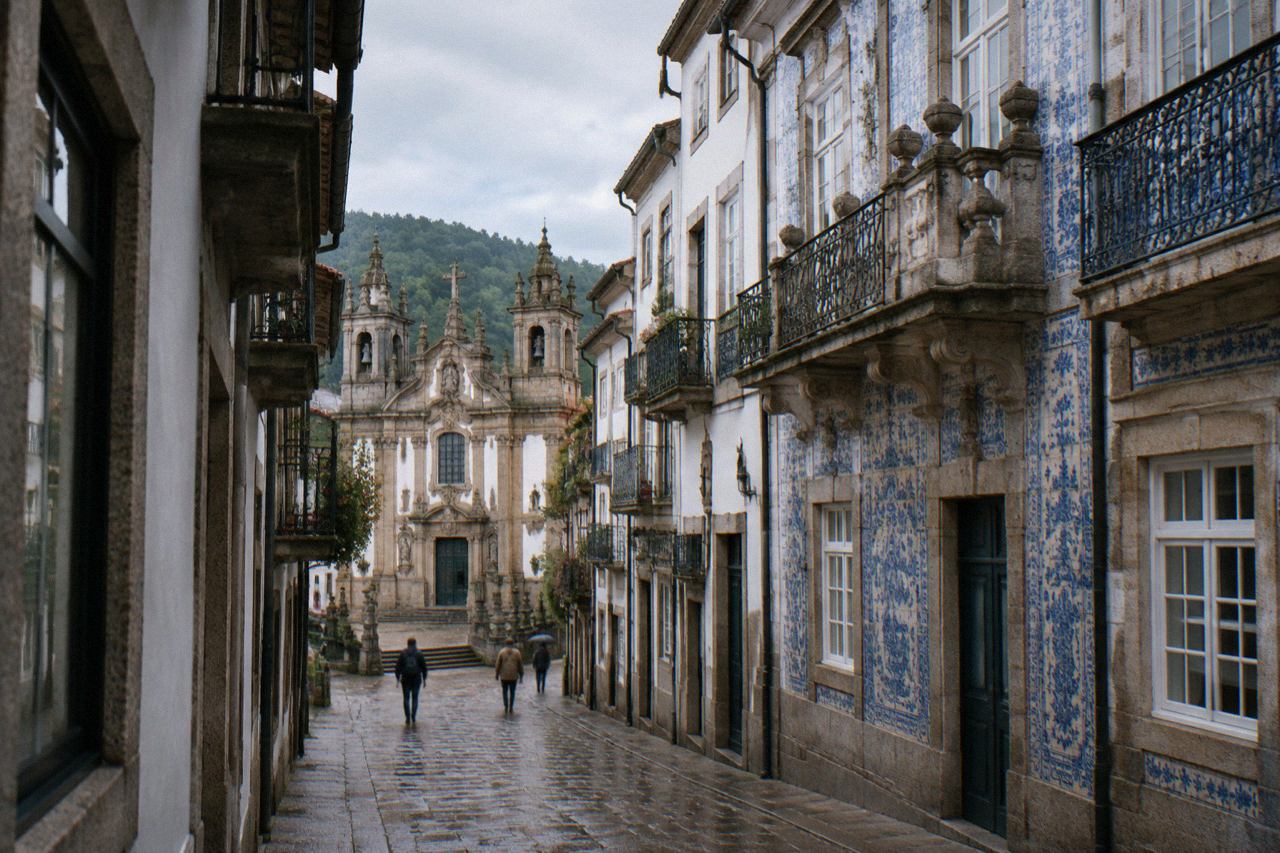 Ornate baroque palace facade with tiled panels and stone balconies on a city street in Braga