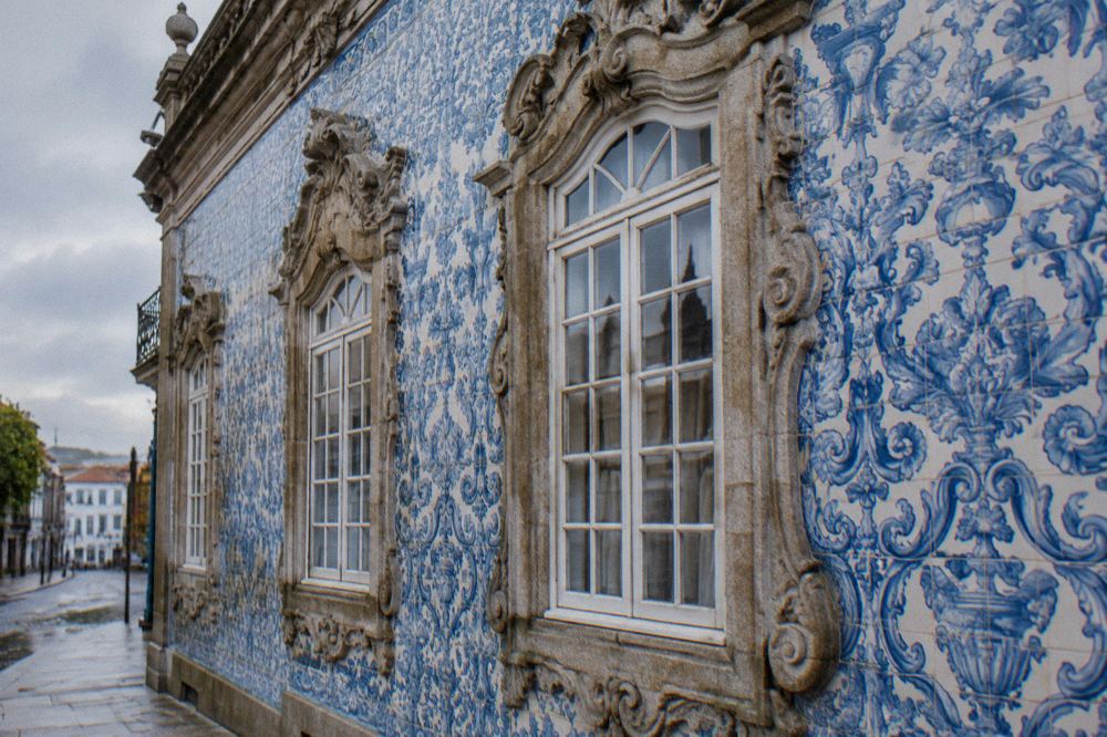 Close view of carved stone window frames and blue and white tiles on a palace wall