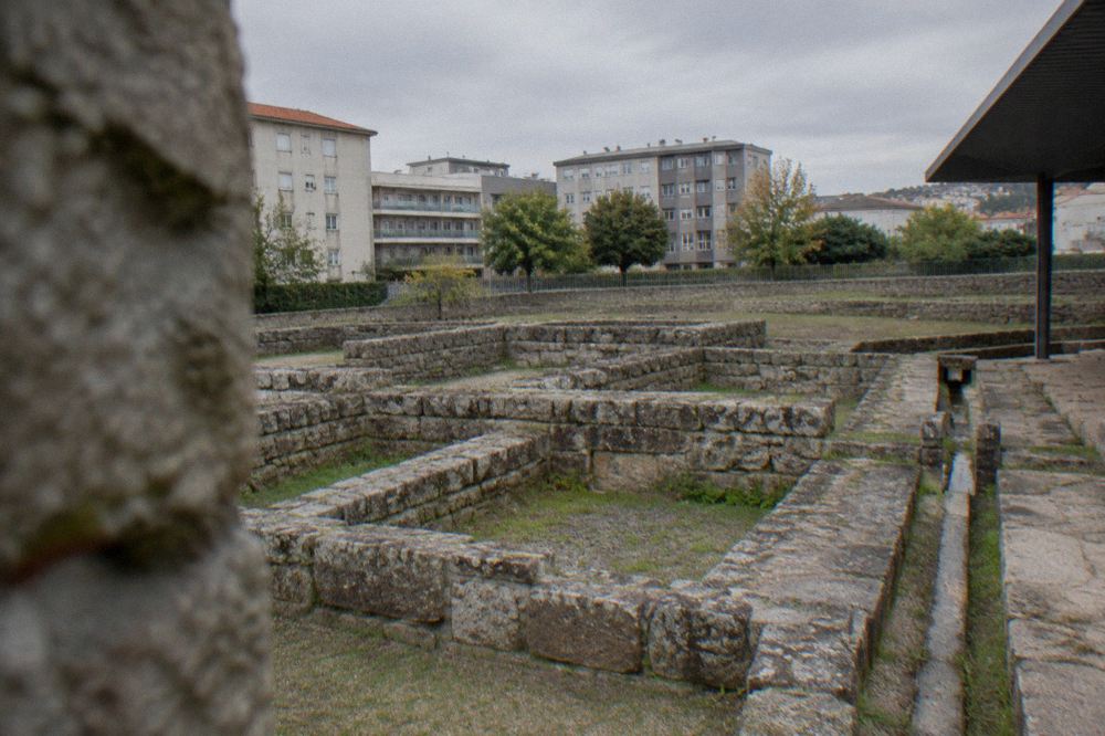 Low stone walls of an excavated Roman bathhouse showing room layouts