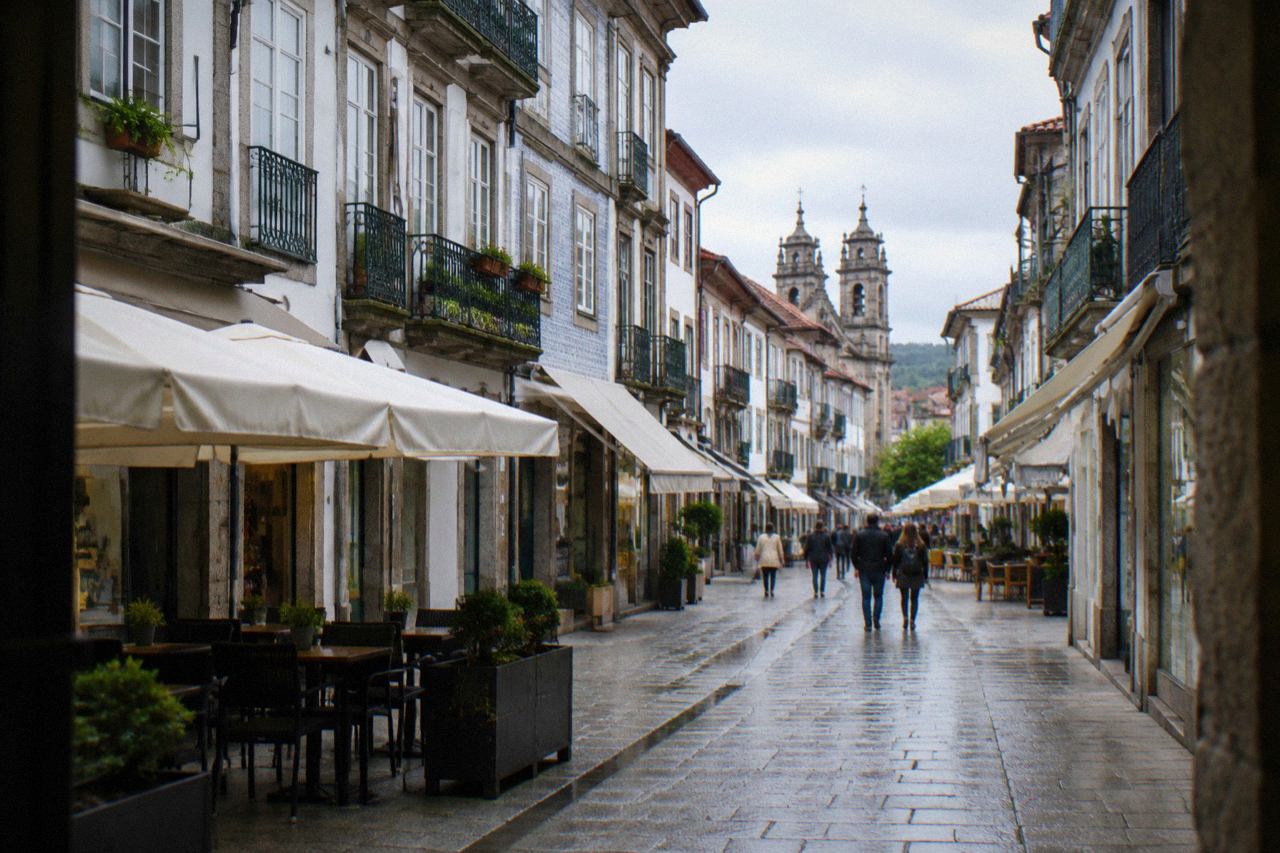 A pedestrian shopping street with café awnings and historic buildings in Braga