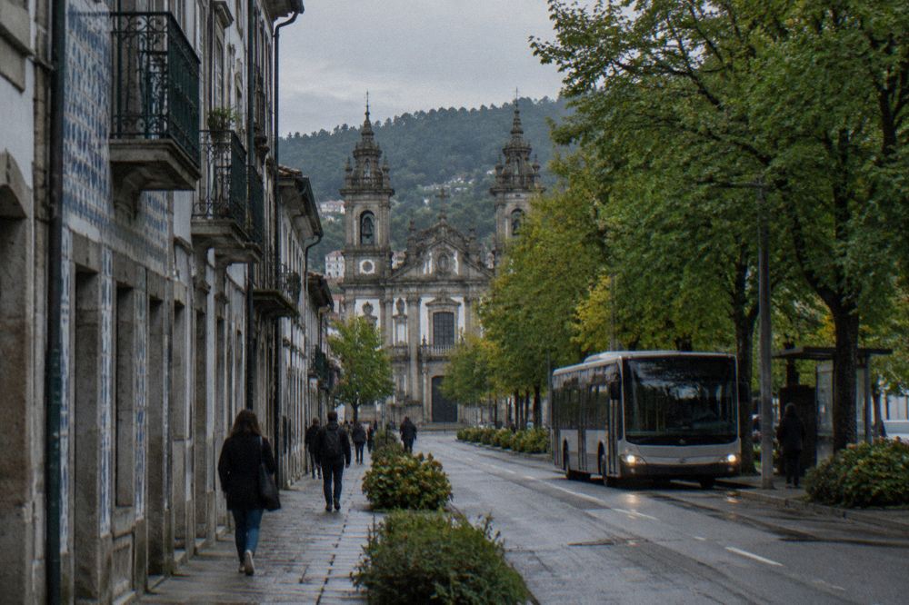 A city bus at a stop on a tree-lined avenue near Braga city centre