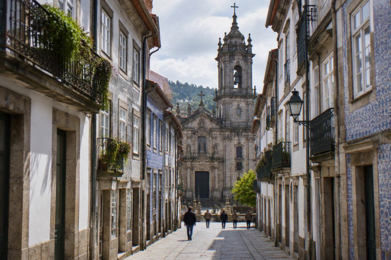 A historic granite church facade with a bell tower in the centre of Braga on a bright day