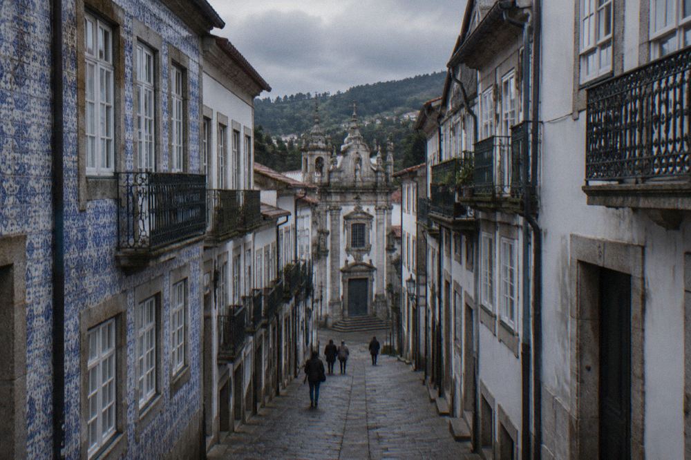 A narrow cobbled street in Braga's historic centre with old buildings in granite