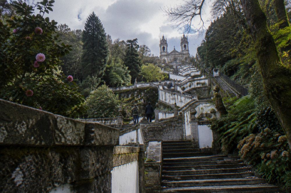 A monumental baroque stairway climbing a wooded hillside toward a church at the top