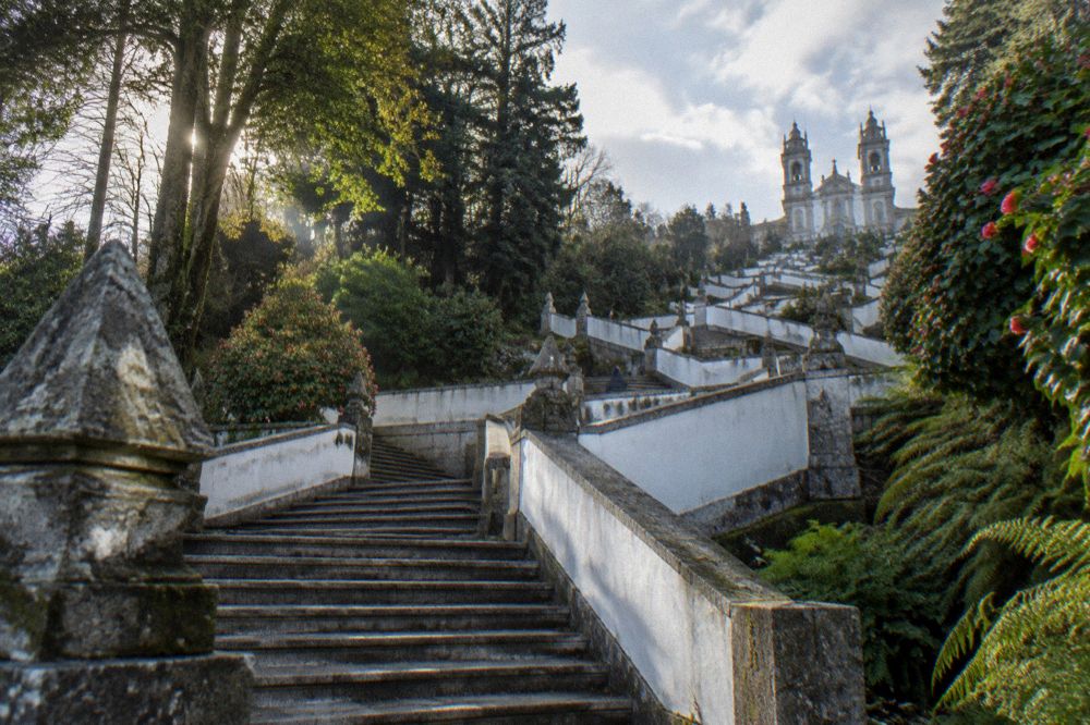 A monumental baroque stairway climbing a terraced hillside toward a church