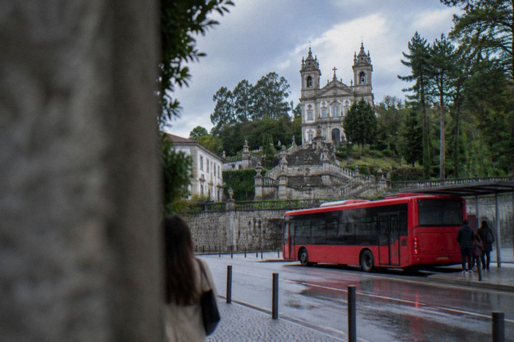 A red city bus stopped at a street stop in a Portuguese city centre