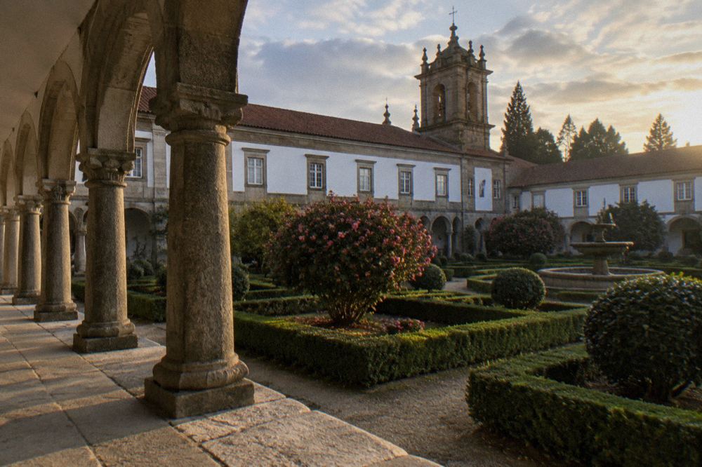 A stone cloister walkway with arched columns at Tibães monastery