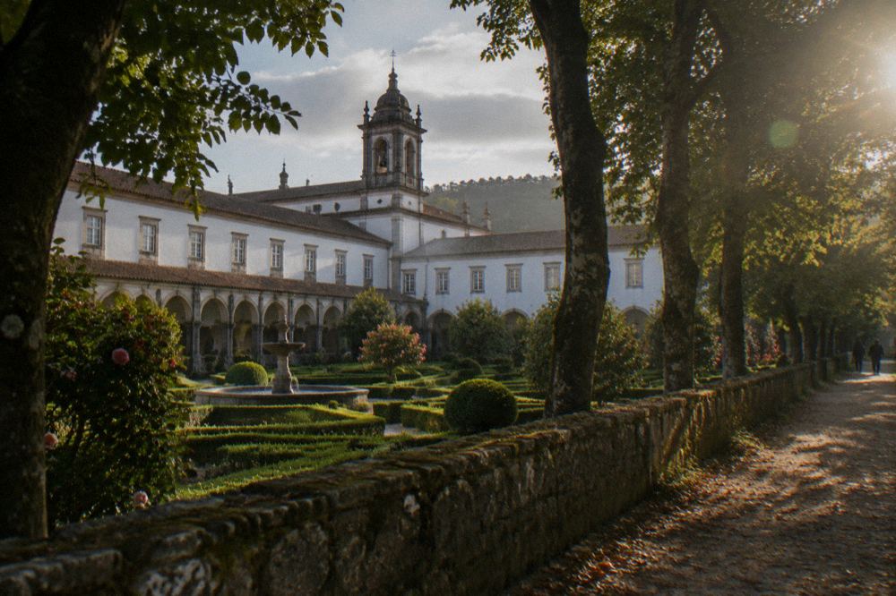 Tree-lined path and stone wall on the monastery grounds at Tibães