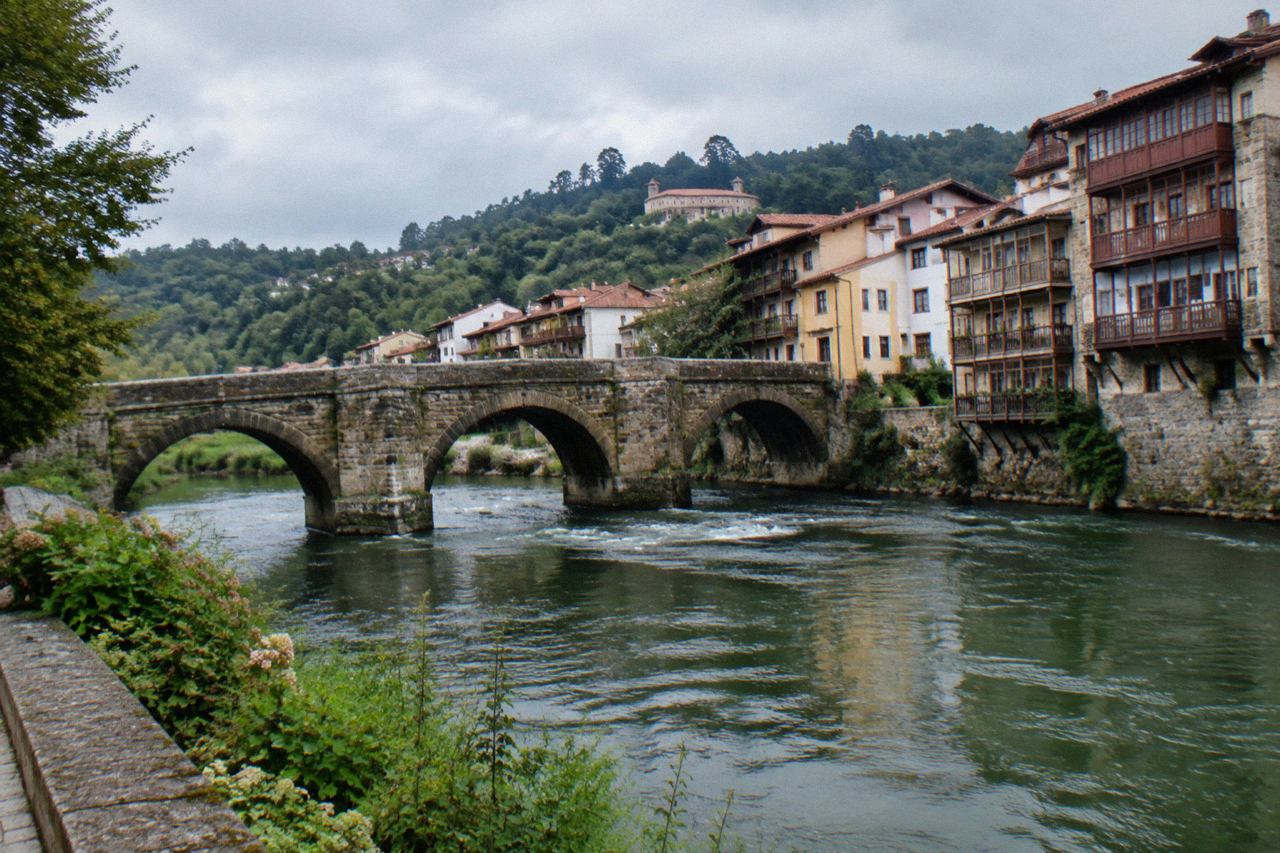 The arched stone bridge and riverside buildings of Amarante seen from the bank of the Tâmega river