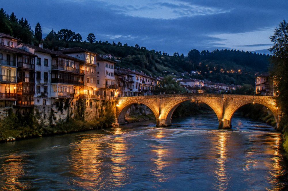 Evening view of the illuminated stone bridge over the Tâmega river in Amarante