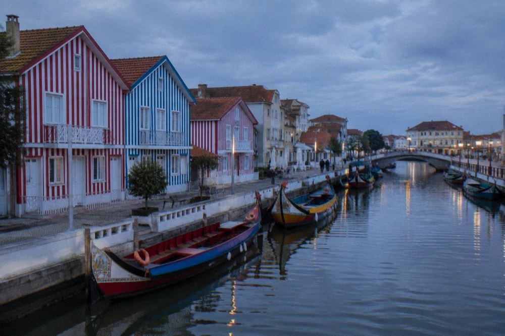 Row of houses painted in bold vertical red and white stripes at Costa Nova