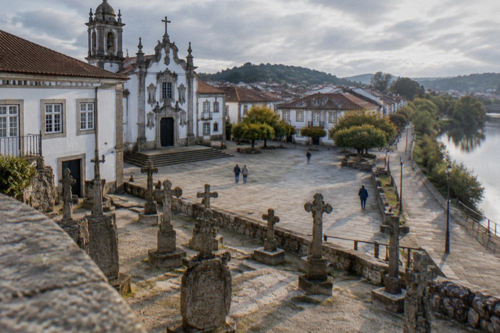 Rows of medieval granite crosses and carved stone coats of arms displayed in an open-air museum courtyard
