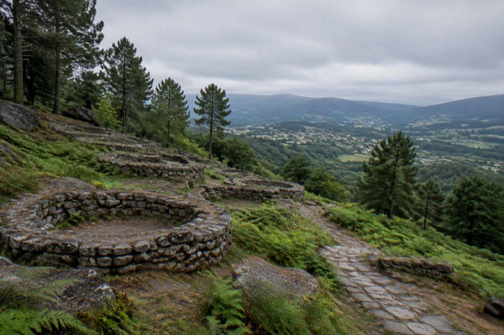 View from the hillfort over green valley fields and distant hills