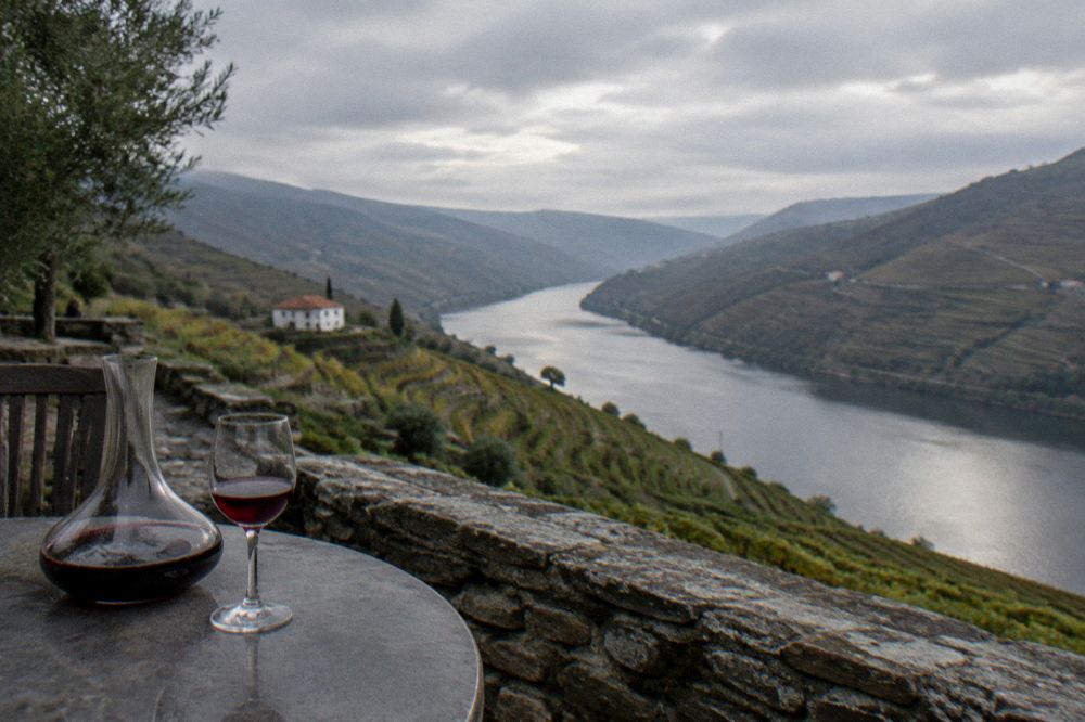 A glass of port wine beside a decanter on a wine estate terrace