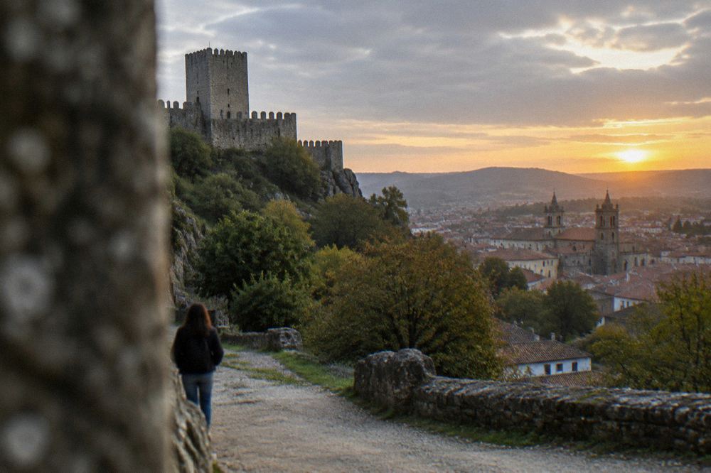 Sunset light over the rooftops and church towers of Guimaraes seen from a hillside path