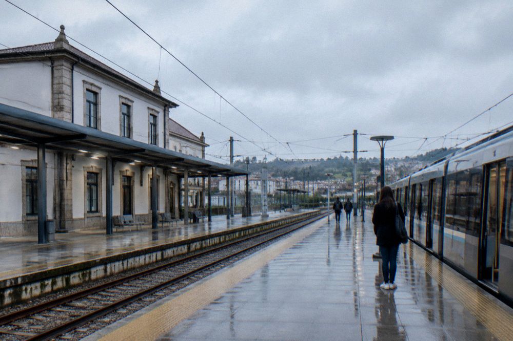 A Porto metro station platform with a modern train and a passenger consulting a map