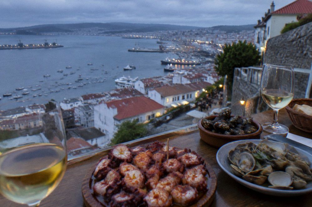 A Galician bar counter with octopus, shellfish and glasses of white wine